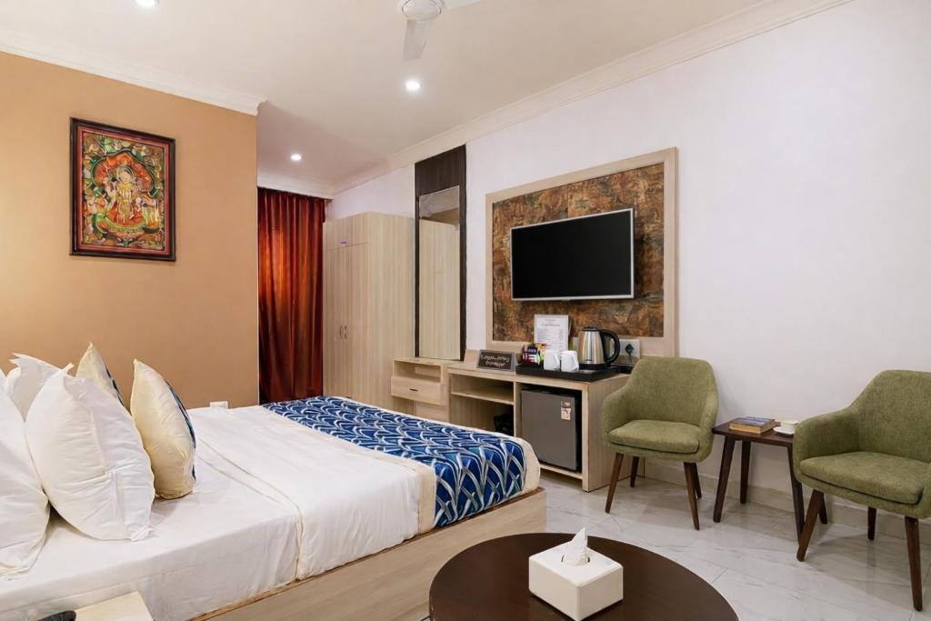 a hotel room with a bed and a desk and a tv at Hotel Stay Premium- Free Airport Tranffer in New Delhi
