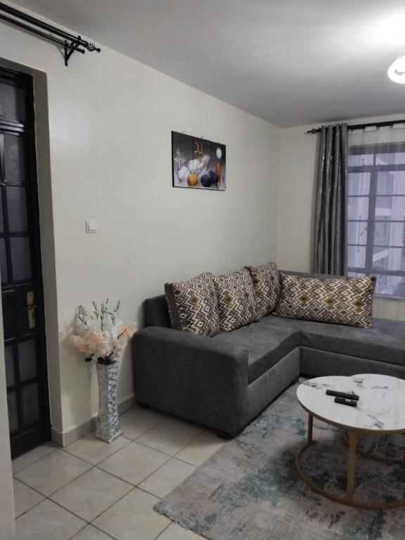 a living room with a couch and a table at Achievers stays in Kitengela 