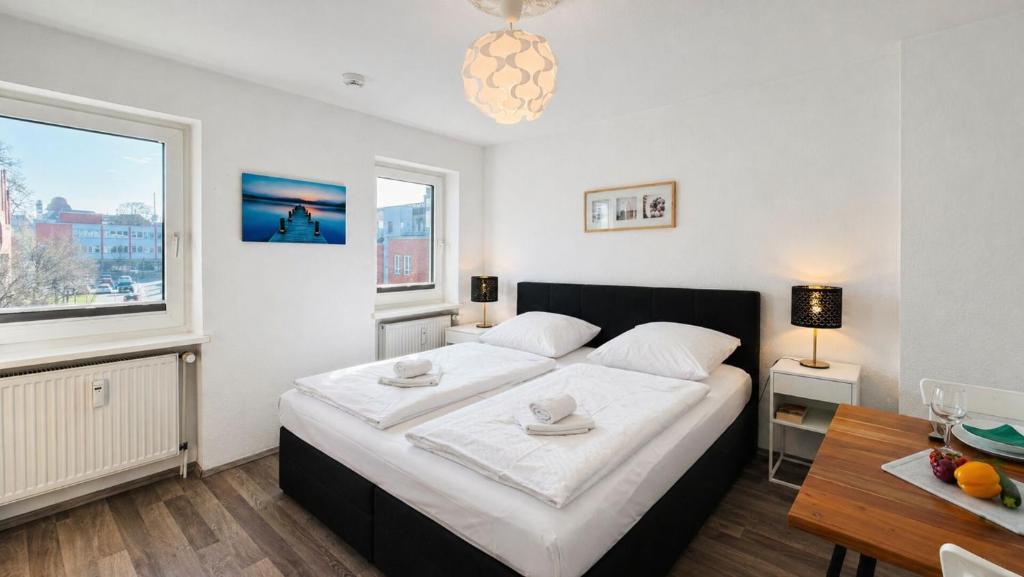 a bedroom with a bed and a desk and a window at CBlue "Apartmenthaus Padua", zentral in Warnemünde