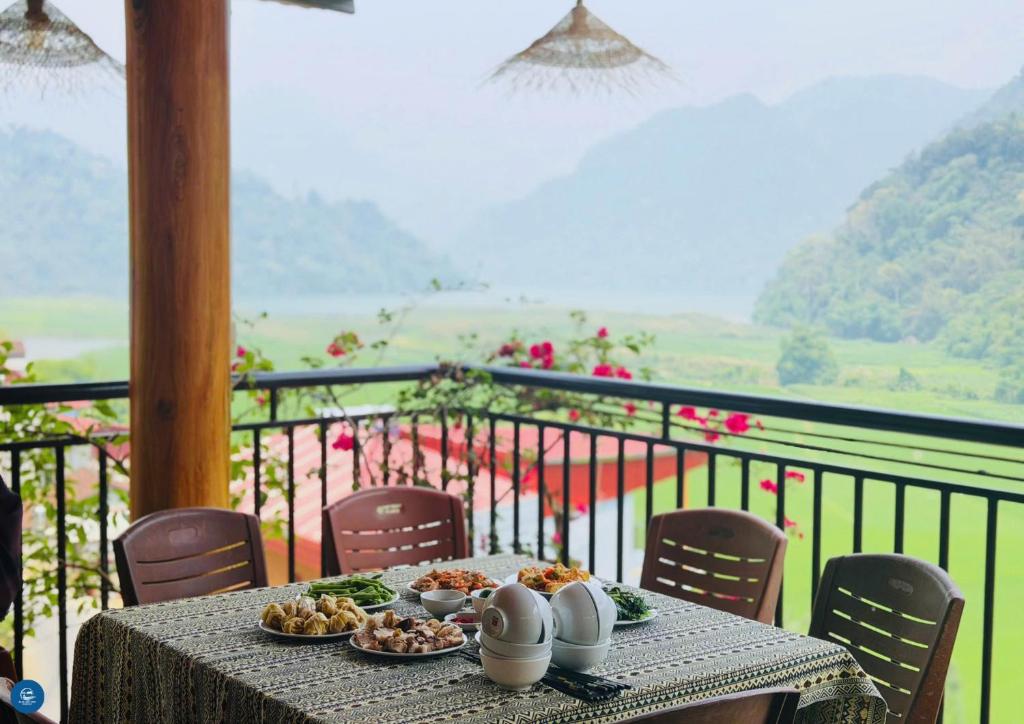 a table with plates of food on top of a balcony at Ba Be Lake View Homestay in An Ma