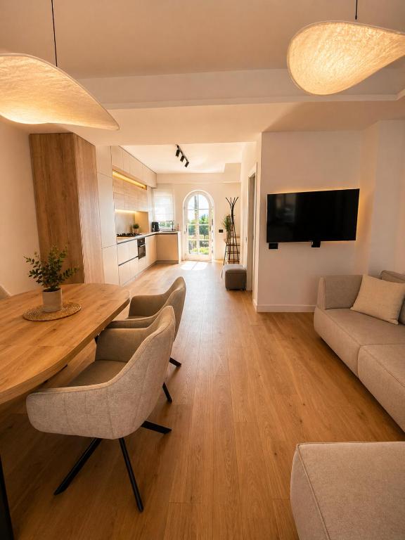 a living room with a large wooden table and chairs at Da Vinci Luxury Home Otopeni in Otopeni