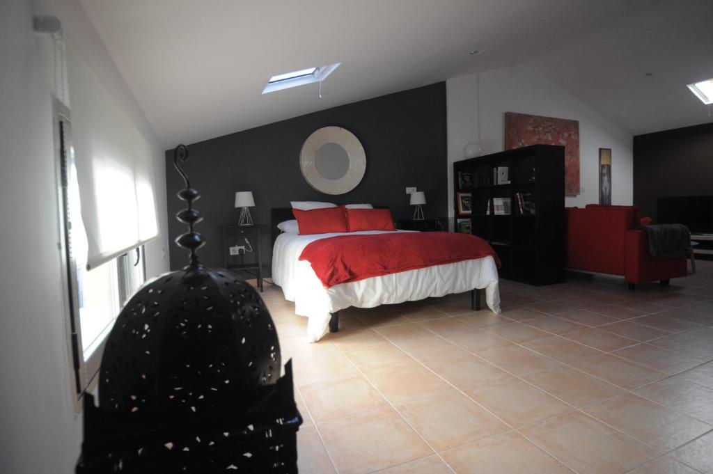 1 dormitorio con 1 cama grande con almohadas rojas en Cuencaloft La casa de Los Moralejos, en Cuenca