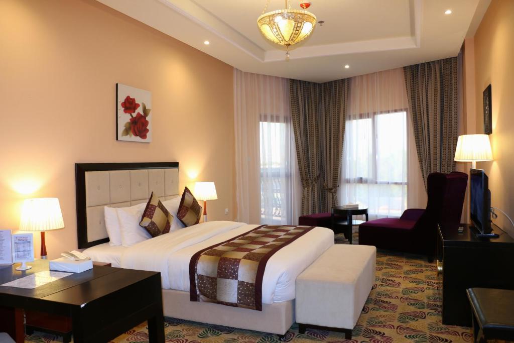 a hotel room with a large bed and a desk at Red Castle Hotel in Sharjah