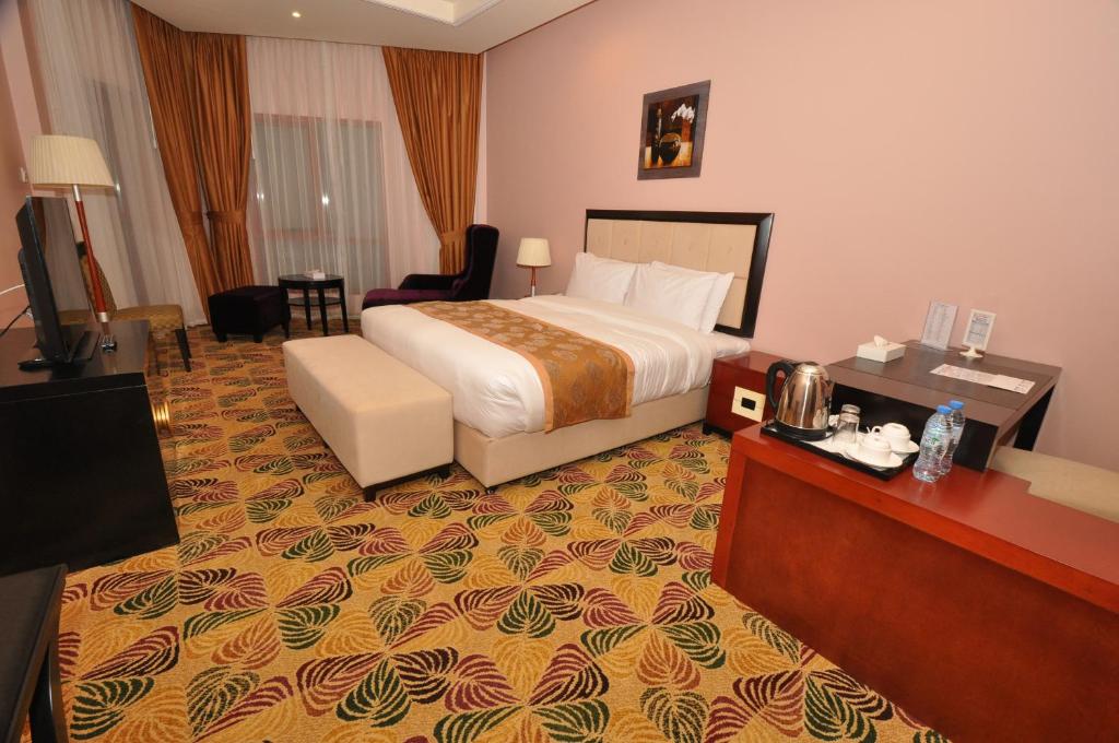 a hotel room with a bed and a television at Red Castle Hotel in Sharjah