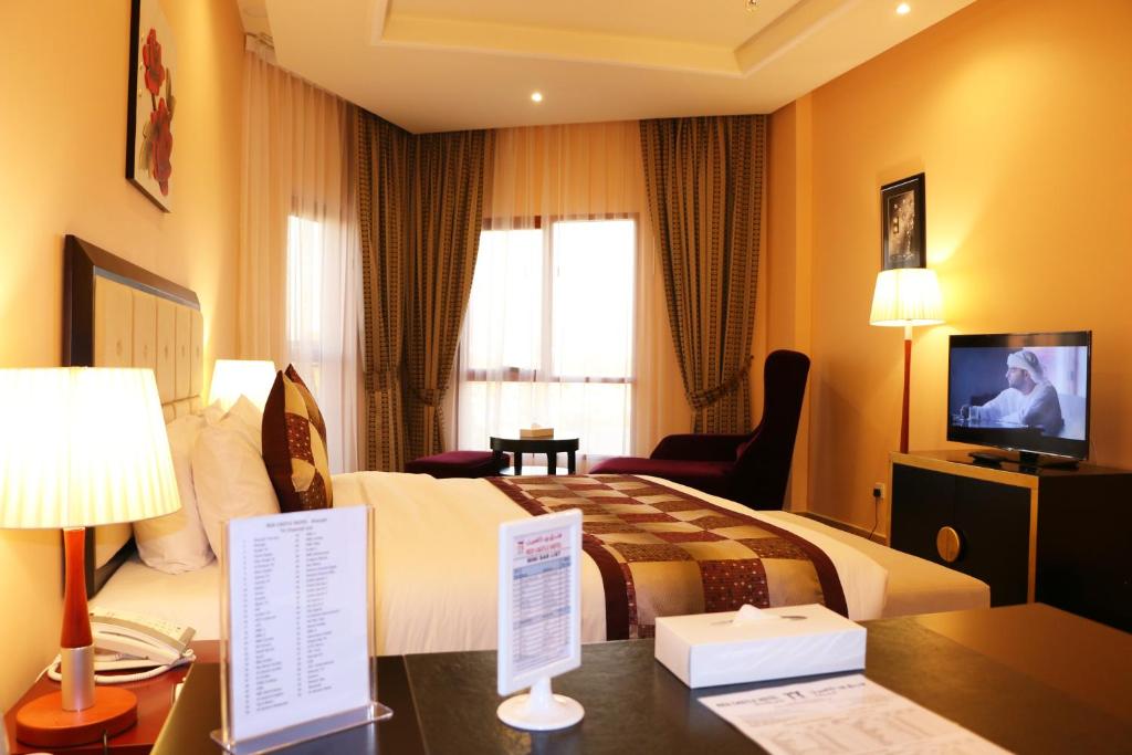 a hotel room with a bed and a television at Red Castle Hotel in Sharjah
