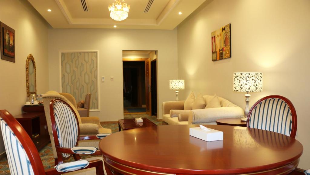 a living room with a table and chairs and a couch at Red Castle Hotel in Sharjah