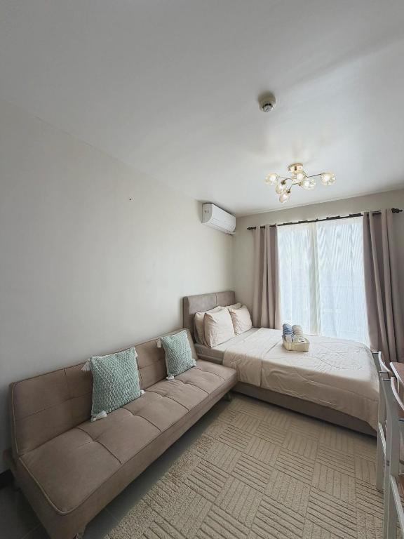 a living room with a couch and a bed at The Purrfect Stay in Lapu Lapu City
