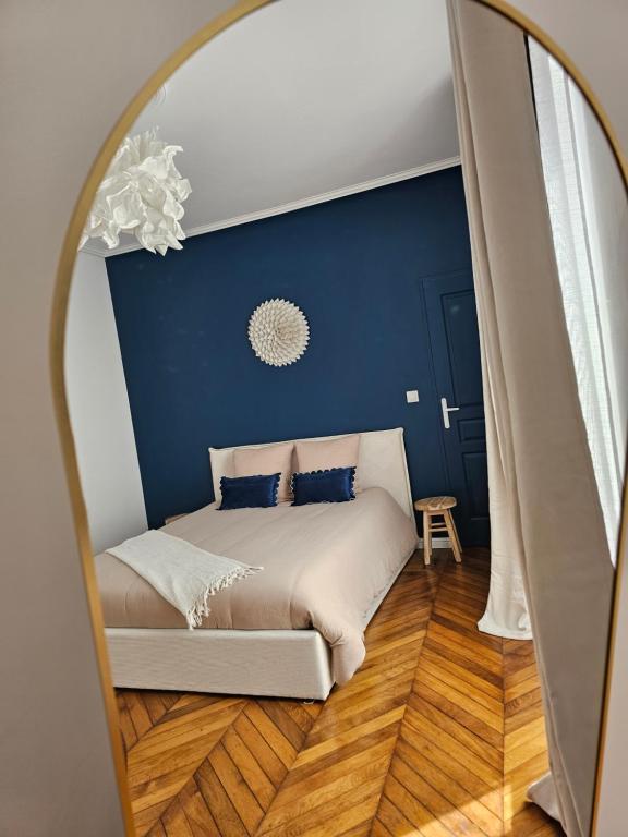 a bedroom with a large bed in a mirror at L'Écrin Manceau Élégance, Sérénité & Confort in Le Mans