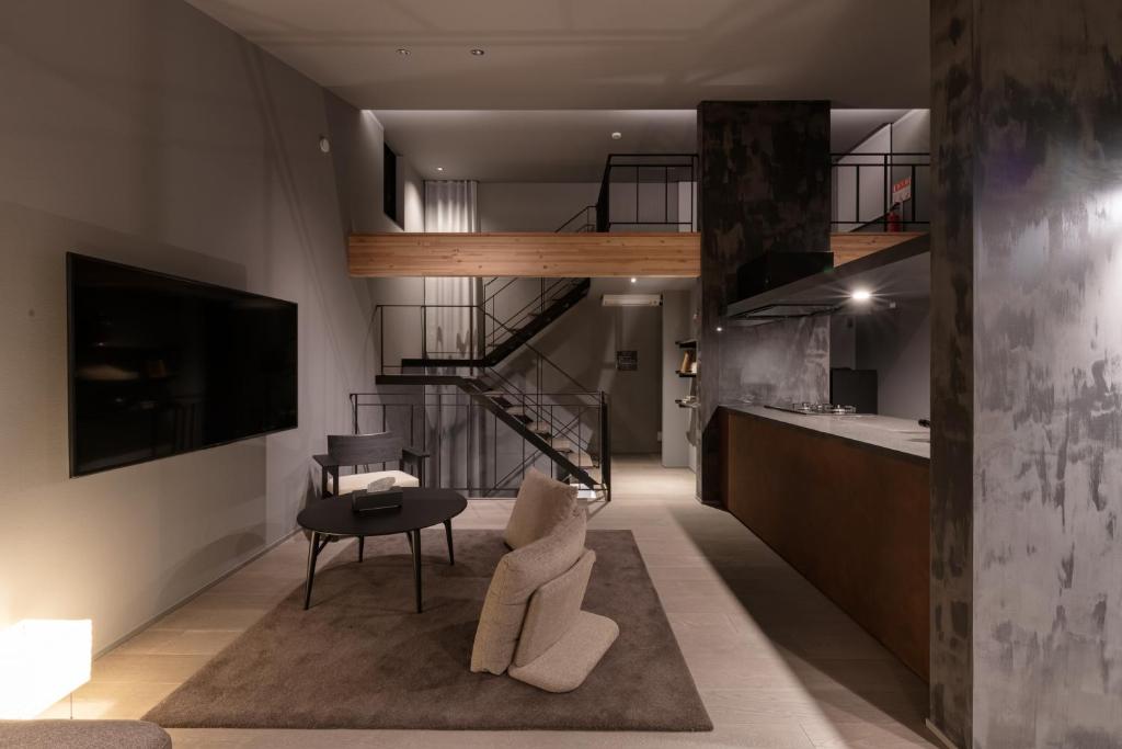 a living room with a staircase and a table at YOHAKU inuyama in Inuyama