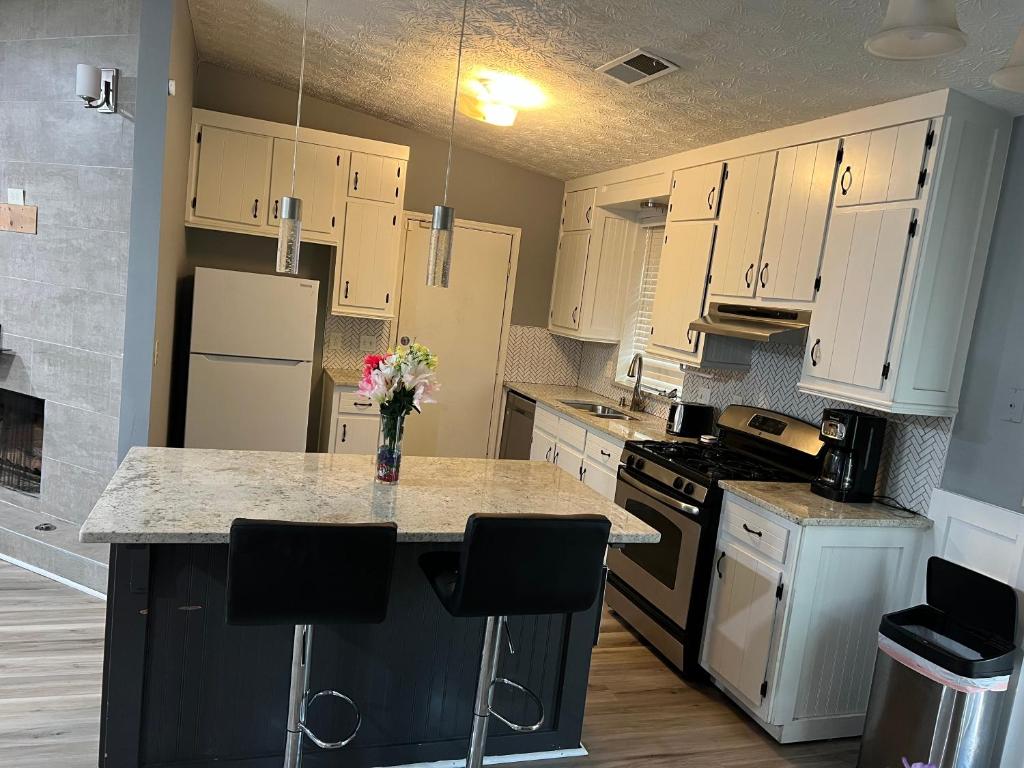 a kitchen with white cabinets and a counter with flowers on it at Sweet Spot Stone Mountain in Stone Mountain
