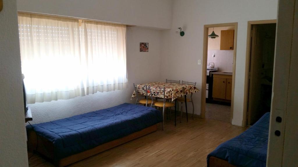 Habitación pequeña con 2 camas y mesa. en Frente al Mar en Mar del Plata