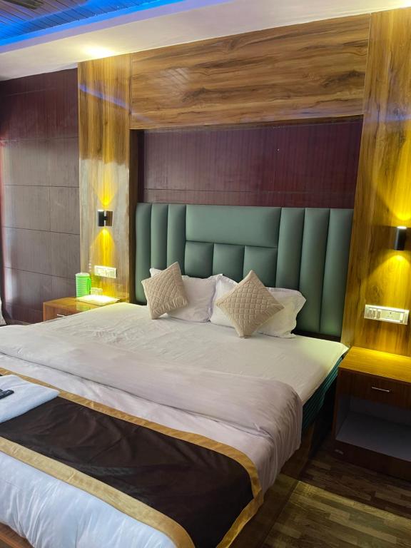 a bedroom with a large bed with a green headboard at Jungle Beach Resort in Neil Island