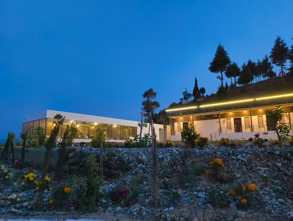 a building at night with flowers in front of it at Samlaun in Pauri