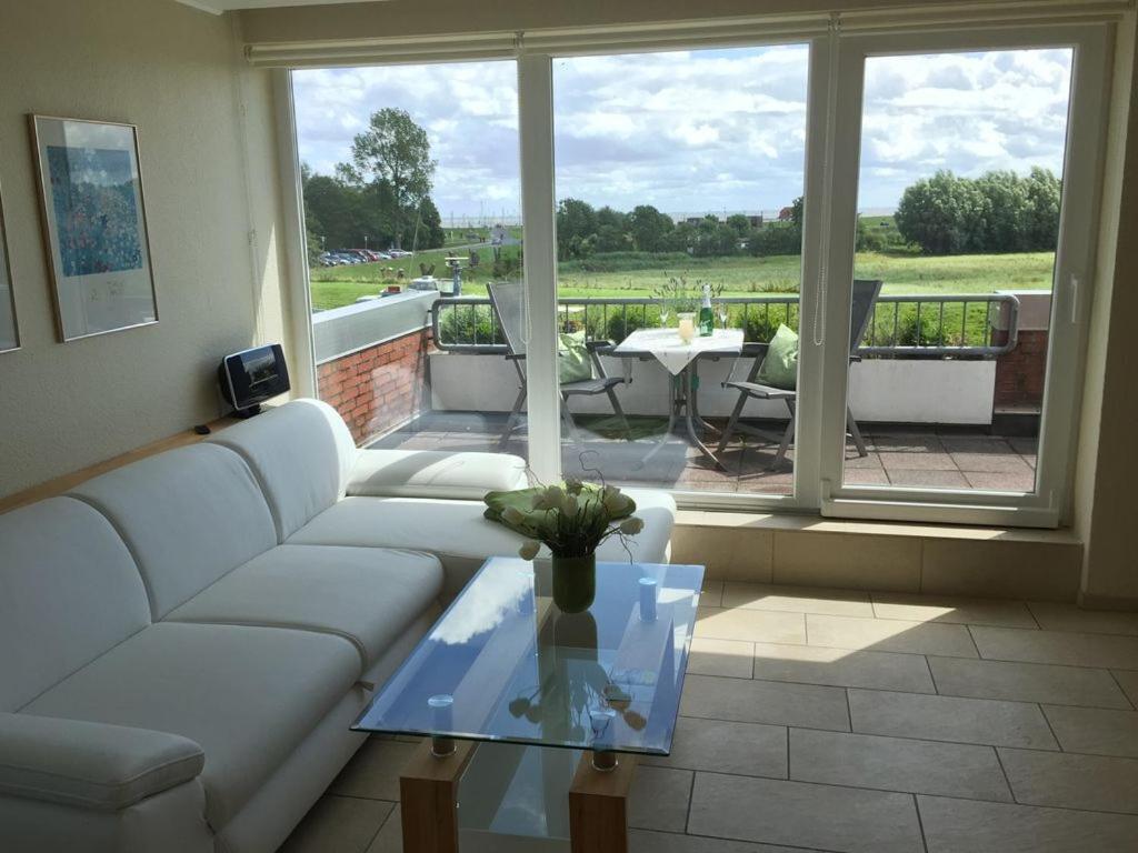 a living room with a white couch and a glass table at Mein Horumersiel in Horumersiel