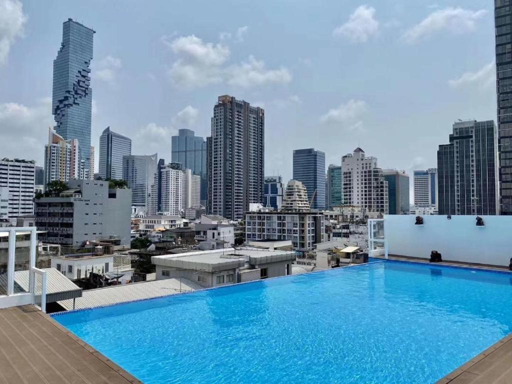a large swimming pool on top of a building with a city skyline at Sapphire Hotel Silom Bangkok in Bangkok
