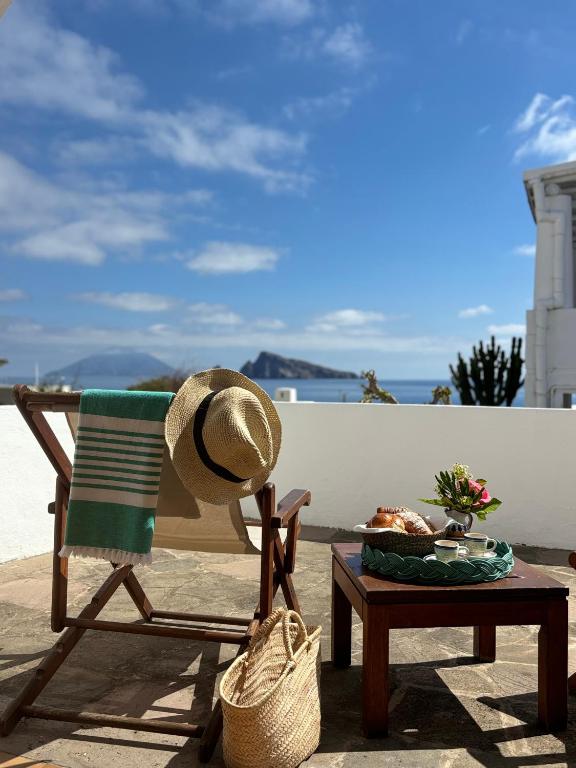 Ein Strohhut liegt auf einem Stuhl neben einem Tisch. in der Unterkunft Hotel Tesoriero in Panarea