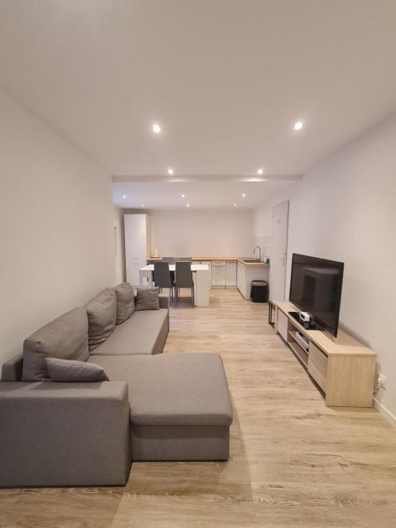 a living room with a couch and a flat screen tv at Keo Home in Arbent