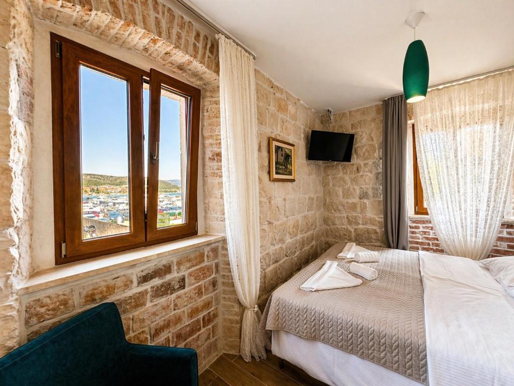 a bedroom with a bed and a window at Boutique Rooms Malo More - Old Town and Parking in Trogir