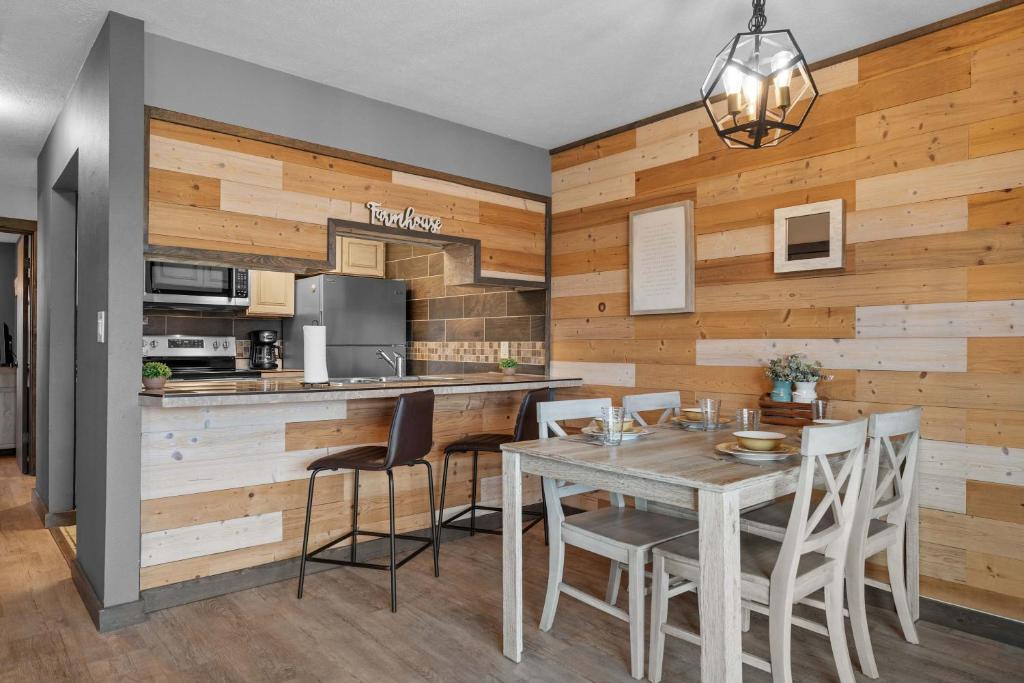 a kitchen with wooden walls and a table and chairs at Hole-in-One Hideaway For 4 in Branson