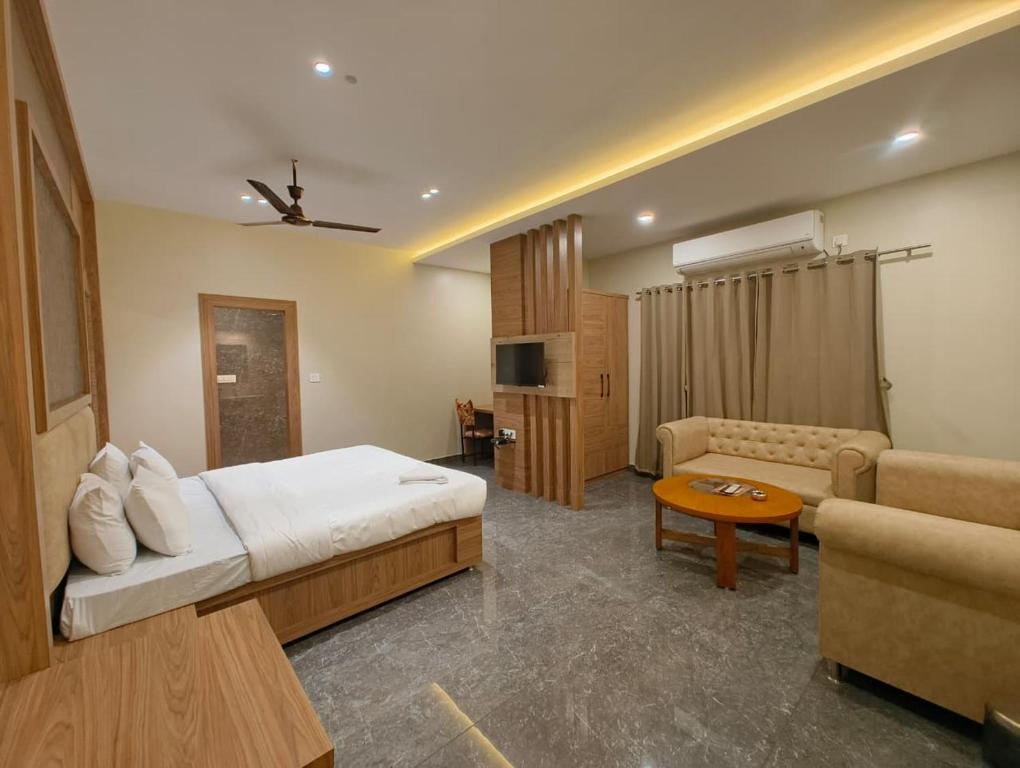 a hotel room with a bed and a living room at Hotel Dolly in Siliguri