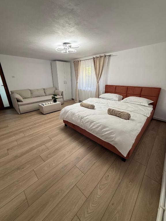 a large bedroom with a large bed and a couch at Casa TeoMar in Brad