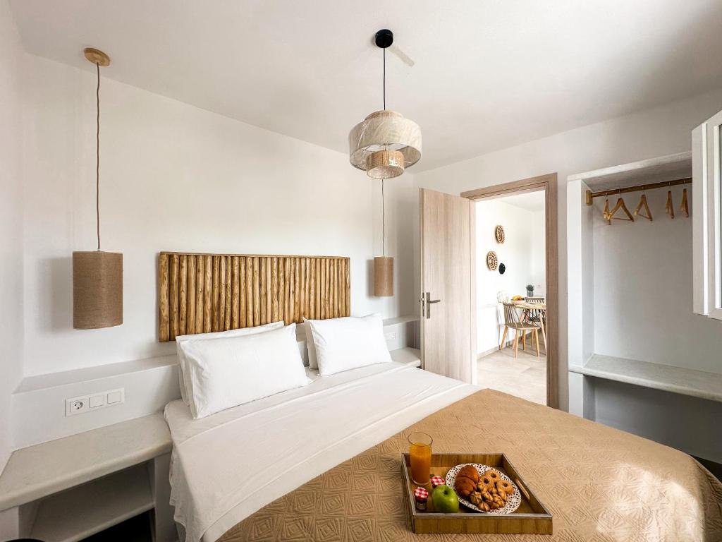 a bedroom with a bed with a tray of food on it at Vigla's Tiny House - Steps to the Beach in Mikri Vigla