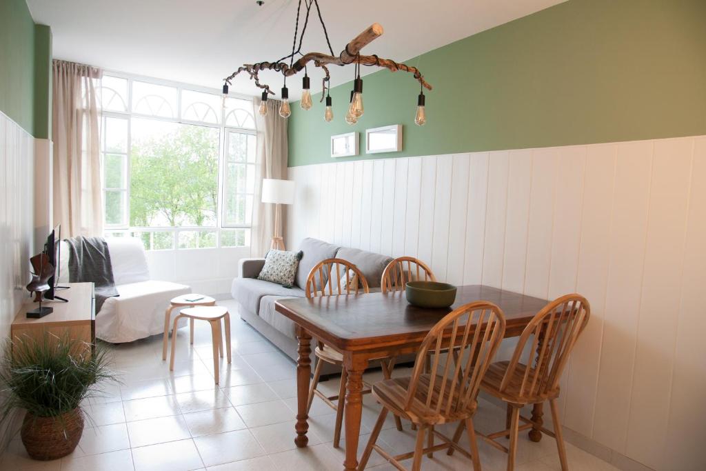 a living room with a table and chairs and a couch at Mar de Louro in Muros