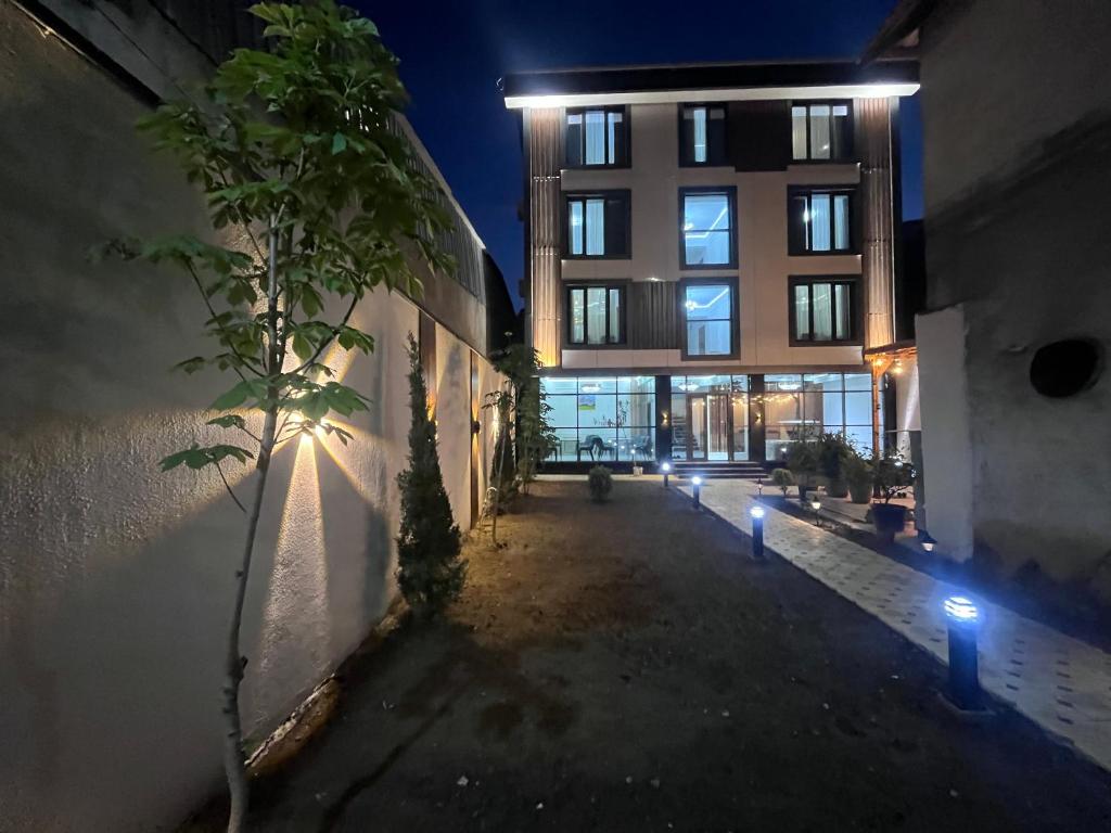 a building with lights on the side of it at night at Pamir Silk Road in Qala-i-Khum