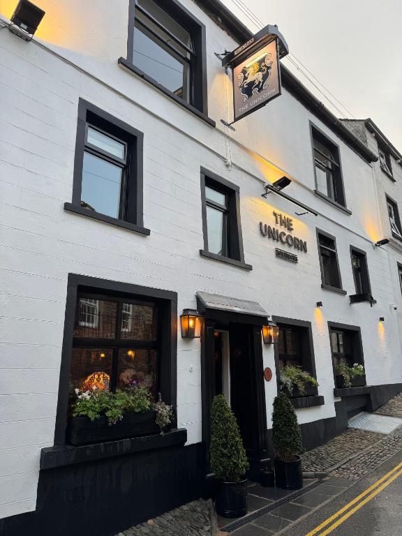 a white building with windows and a sign on it at The Unicorn, Ambleside in Ambleside