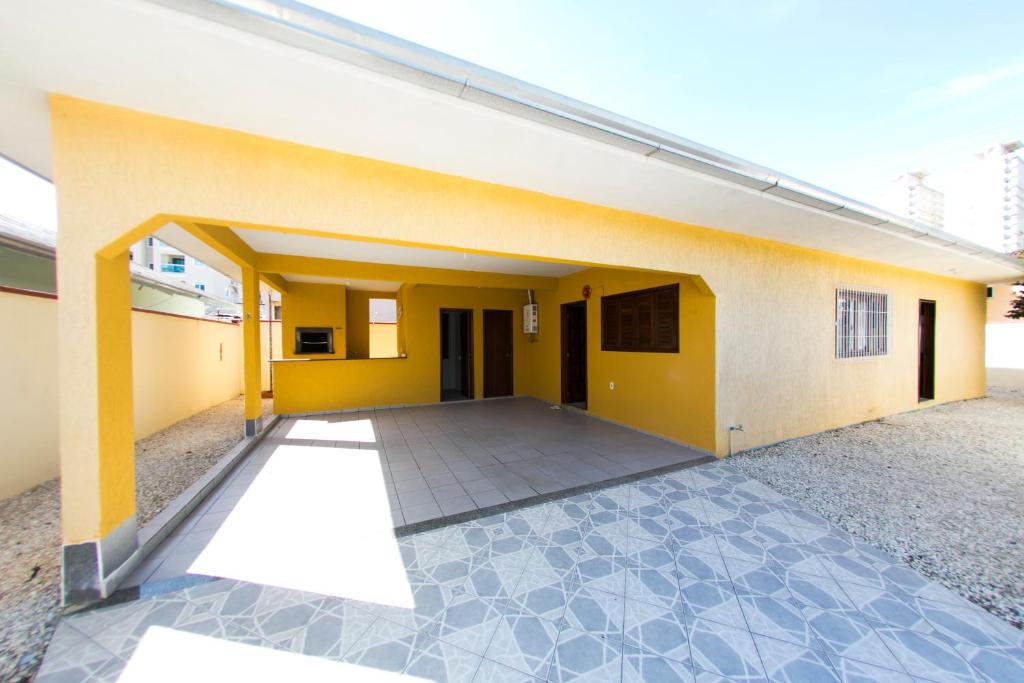 a building with a yellow wall and a patio at BRUNO KLEMTZ RUA 274 CaSA COM PISCINA PRIVATIVA in Itapema