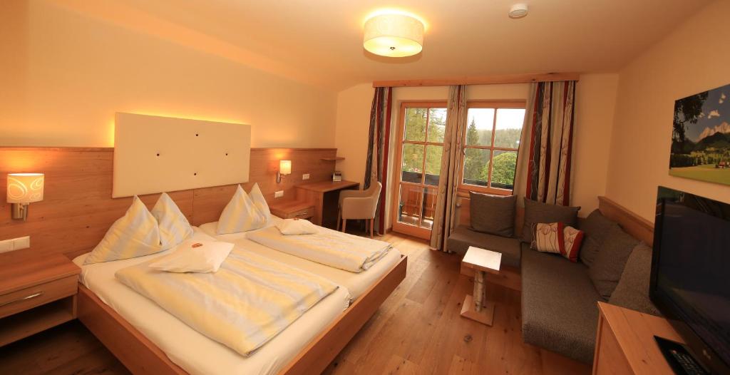 een hotelkamer met een bed en een televisie bij Alpenperle in Ramsau am Dachstein