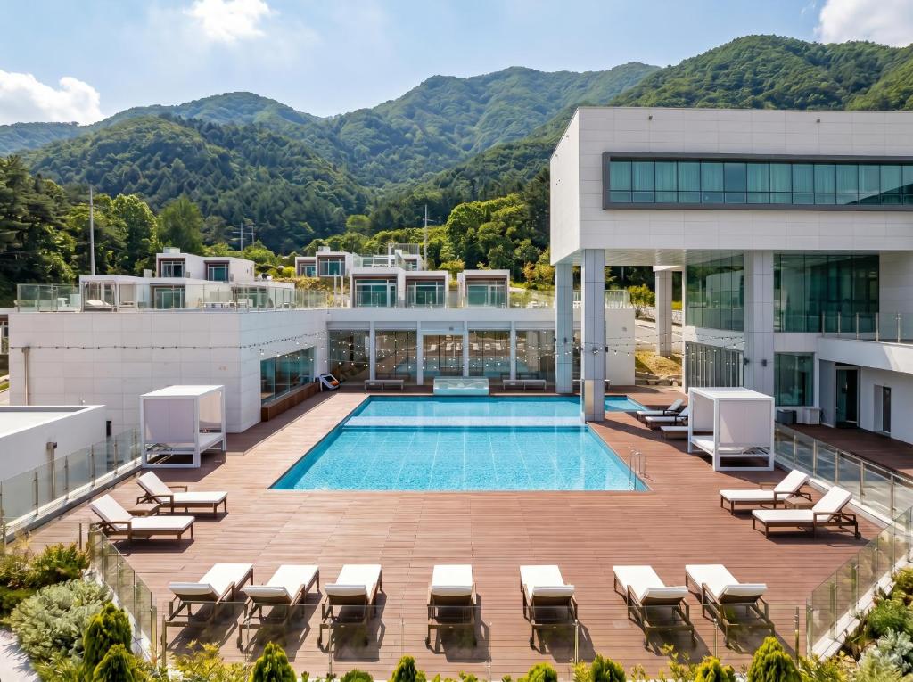 an aerial view of a building with a pool and lounge chairs at Over The Mountain in Gapyeong