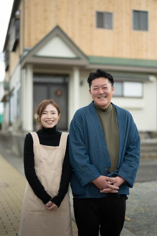 a man and a woman standing on a street at 金木犀 in Kesennuma