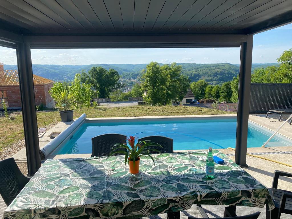 a patio with a table and a swimming pool at Vacances Vallée de la Dordogne in Souillac