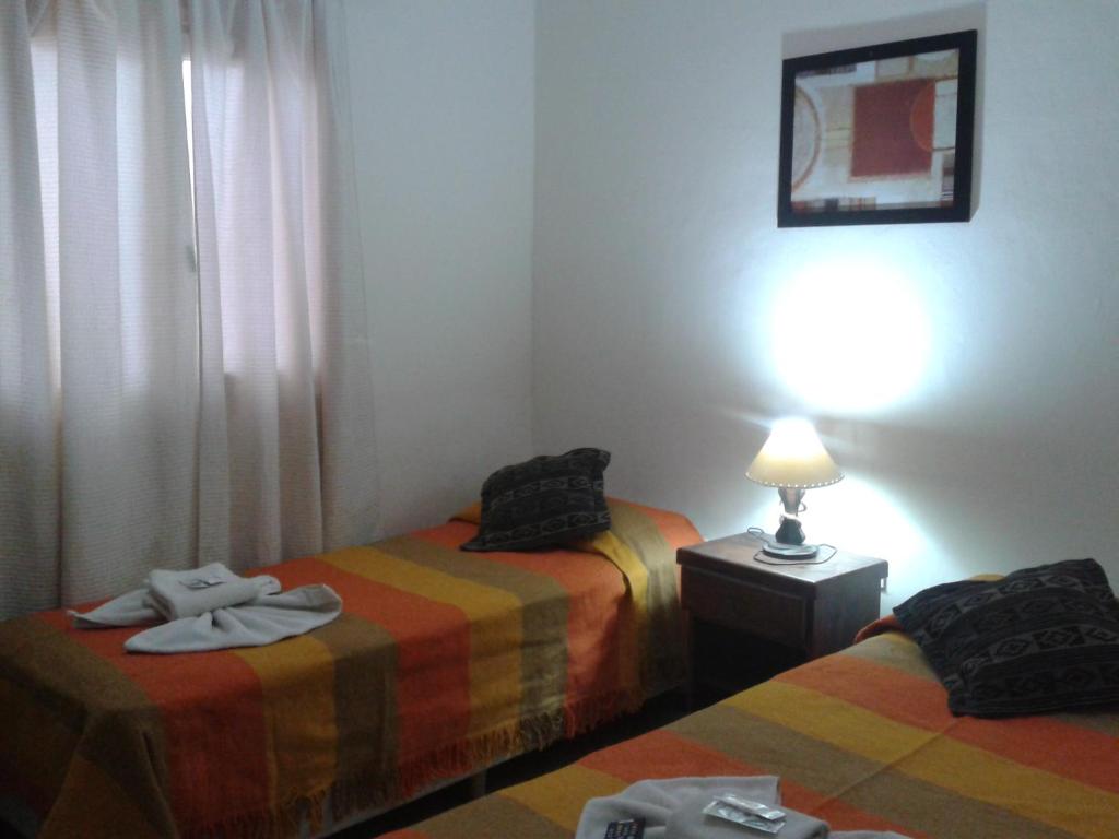 a room with two beds and a lamp on a table at Hotel Wilton in Mar del Plata