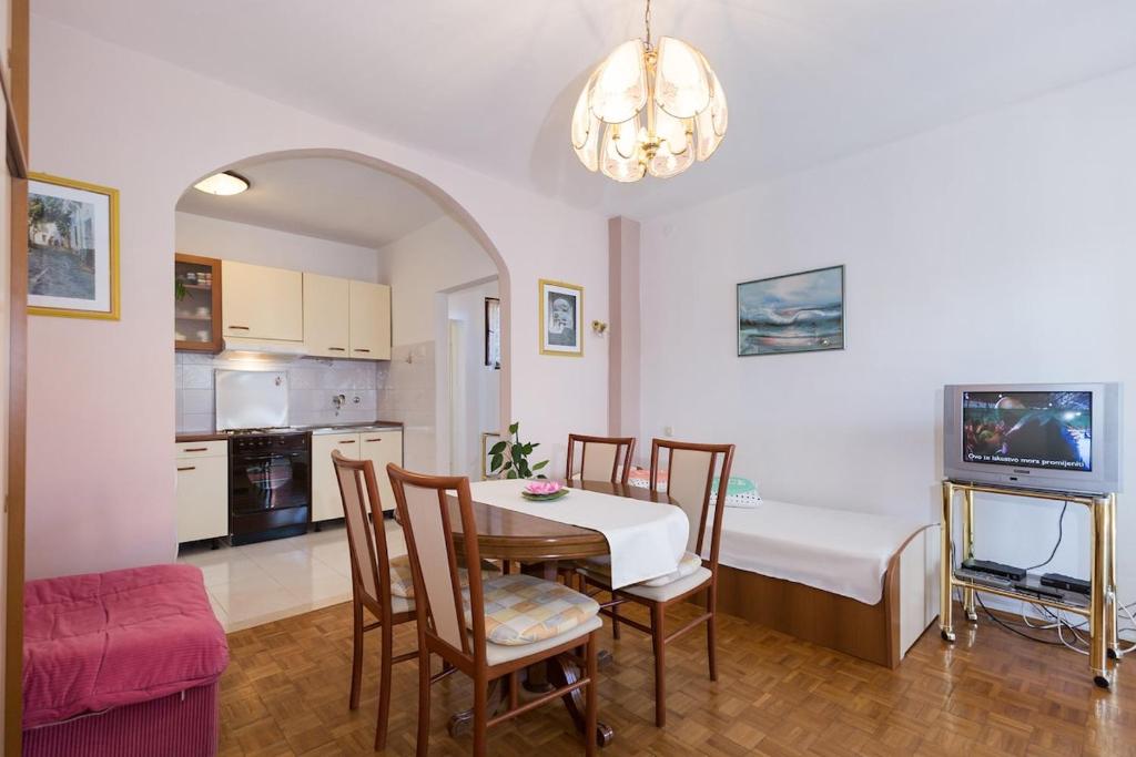 a kitchen and dining room with a table and chairs at House on the sea in Preko