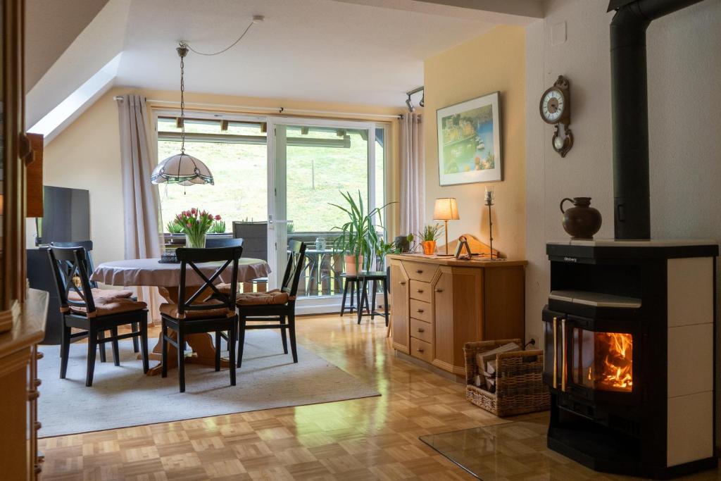 a living room with a table and a fireplace at Ferienwohnung Belchenzeit in Münstertal