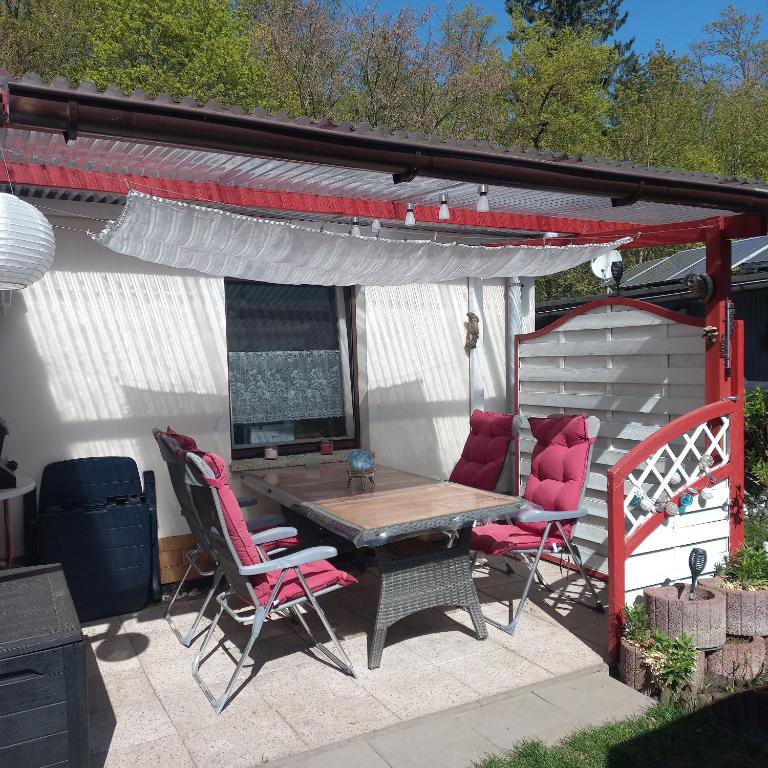 a patio with a table and chairs under awning at Haus Seeblick in Malchow