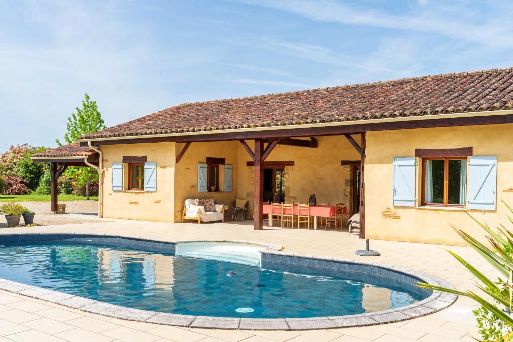 a house with a swimming pool in front of a house at La Jouanhitte in Bourrouillan