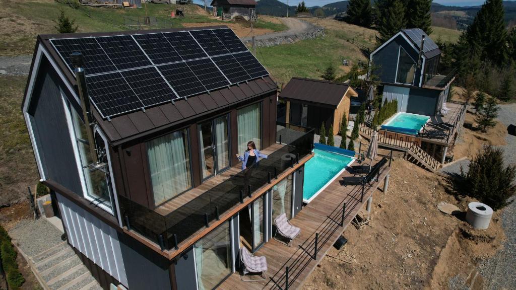 a woman standing on the balcony of a house with a pool at Boho Shale in Yablunytsya