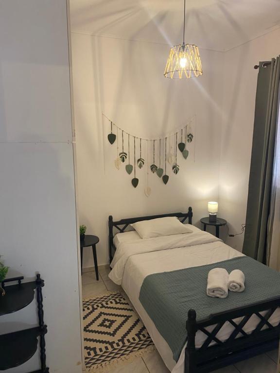 a bedroom with a bed with two towels and a chandelier at Της κυρα Τασιας in Konitsa