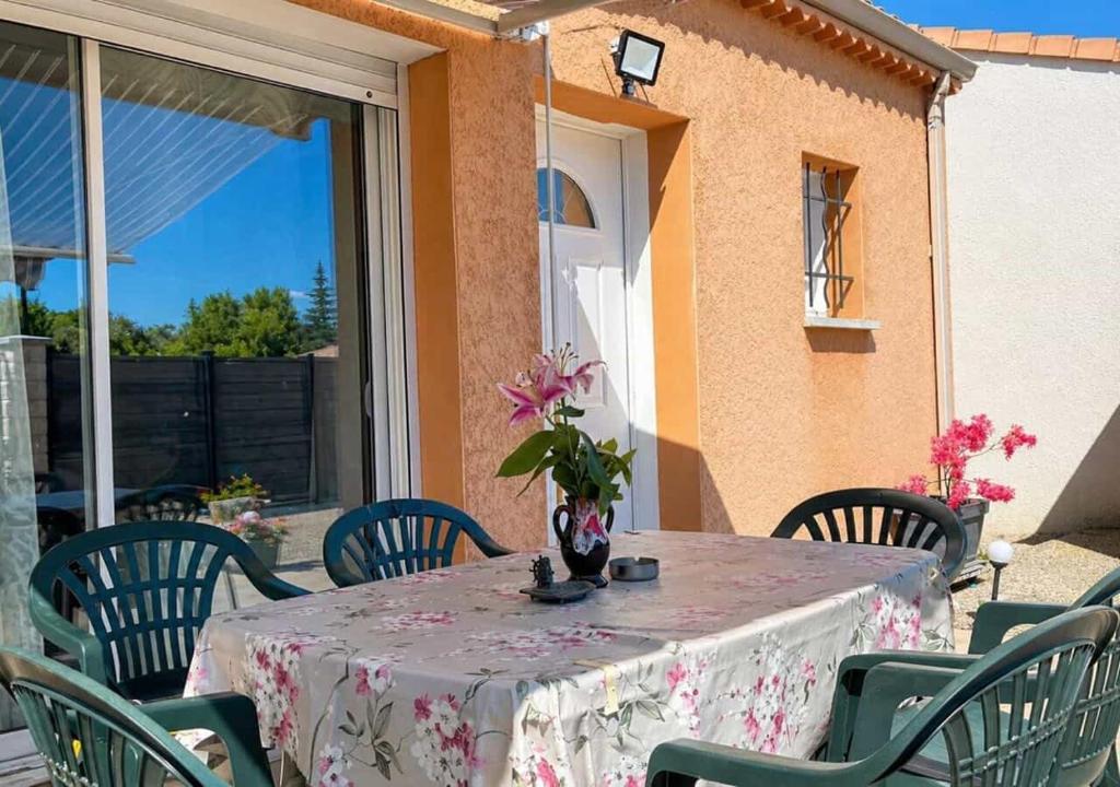 a table with a vase of flowers on a patio at Chambres d'hôtes Drome in Chatuzange-le-Goubet