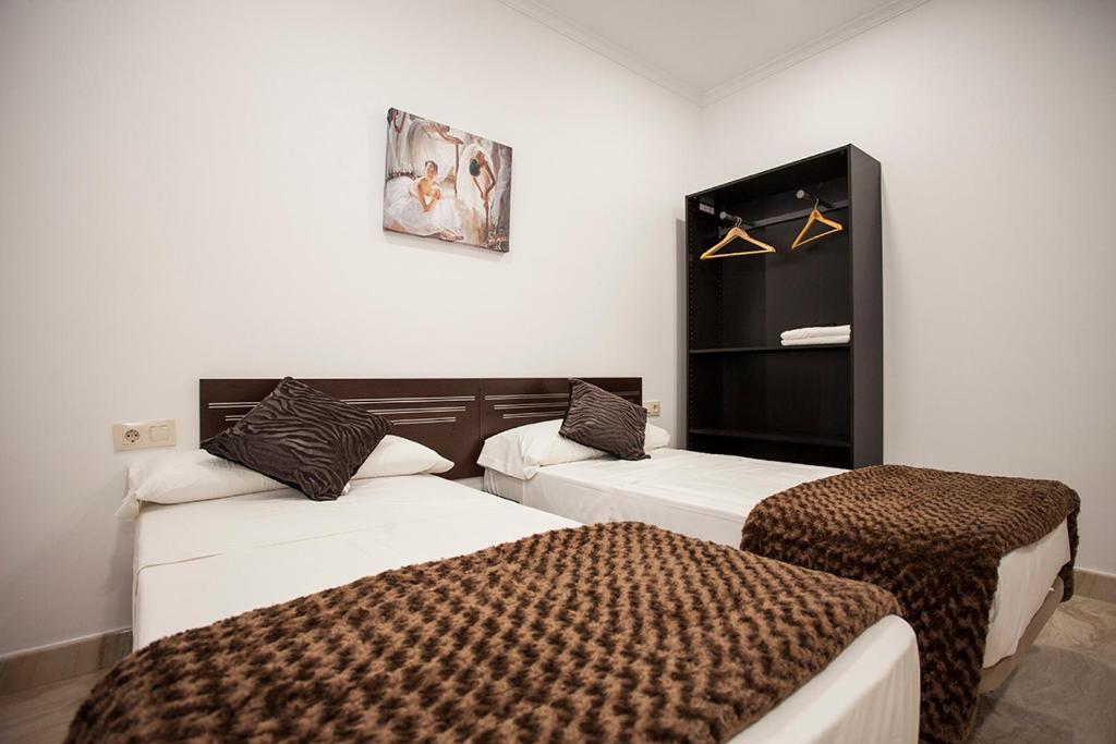 マドリードにあるHostal Rincón de Sol - Centro Madrid - Self Checkinの白い壁の部屋にベッドが2つある