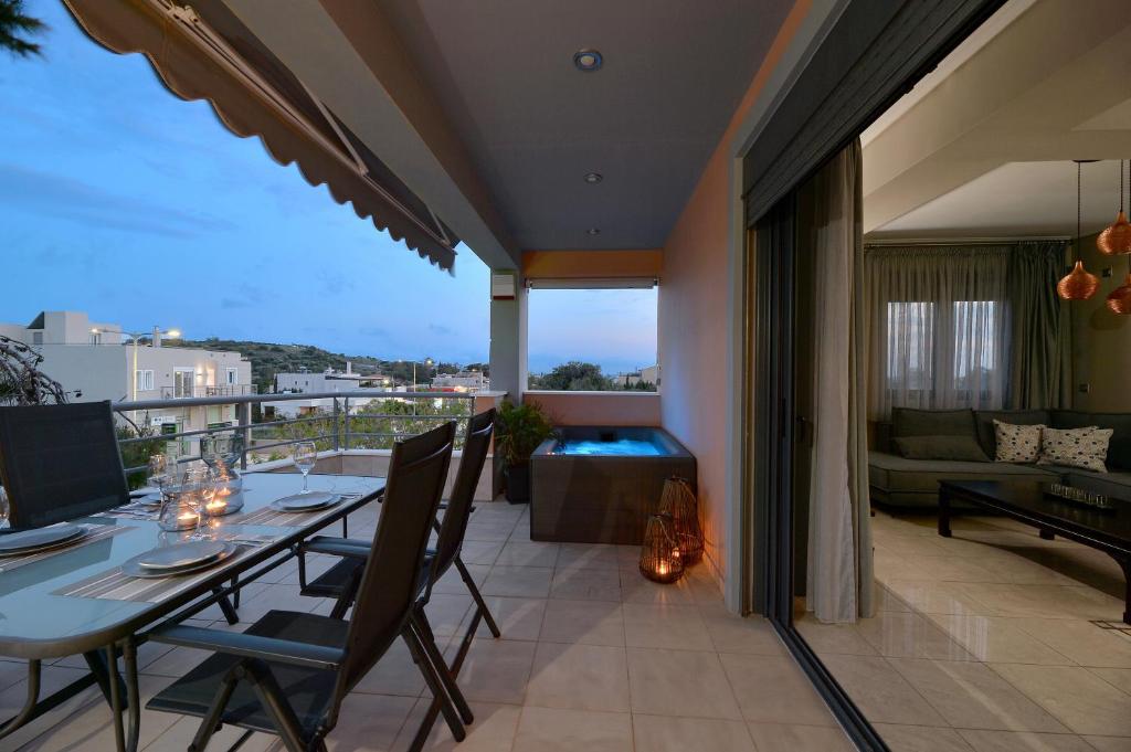 a patio with a table and chairs on a balcony at Lagonisi luxurious residence Nelly's Jacuzzi house in Kalívia Thorikoú
