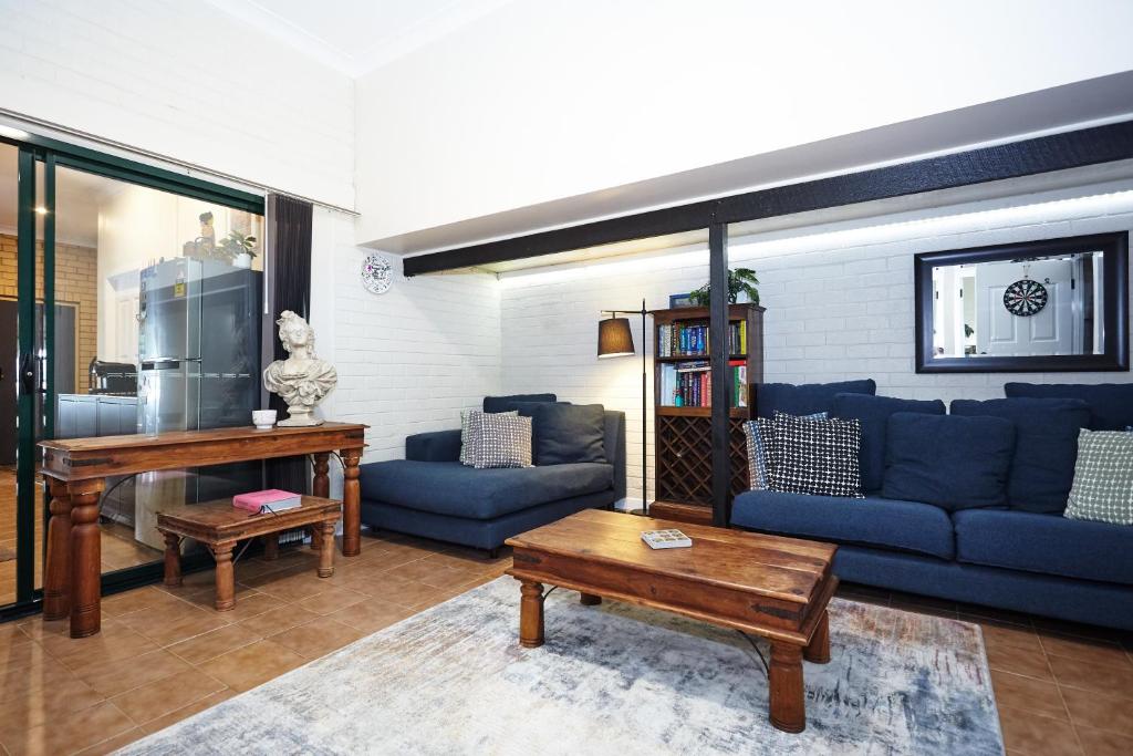 a living room with blue couches and a table at Lismore Hillside Home on Ballina Road in Lismore