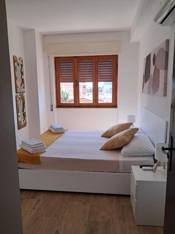 a bedroom with a large bed and a window at Argent House Orbetello in Orbetello