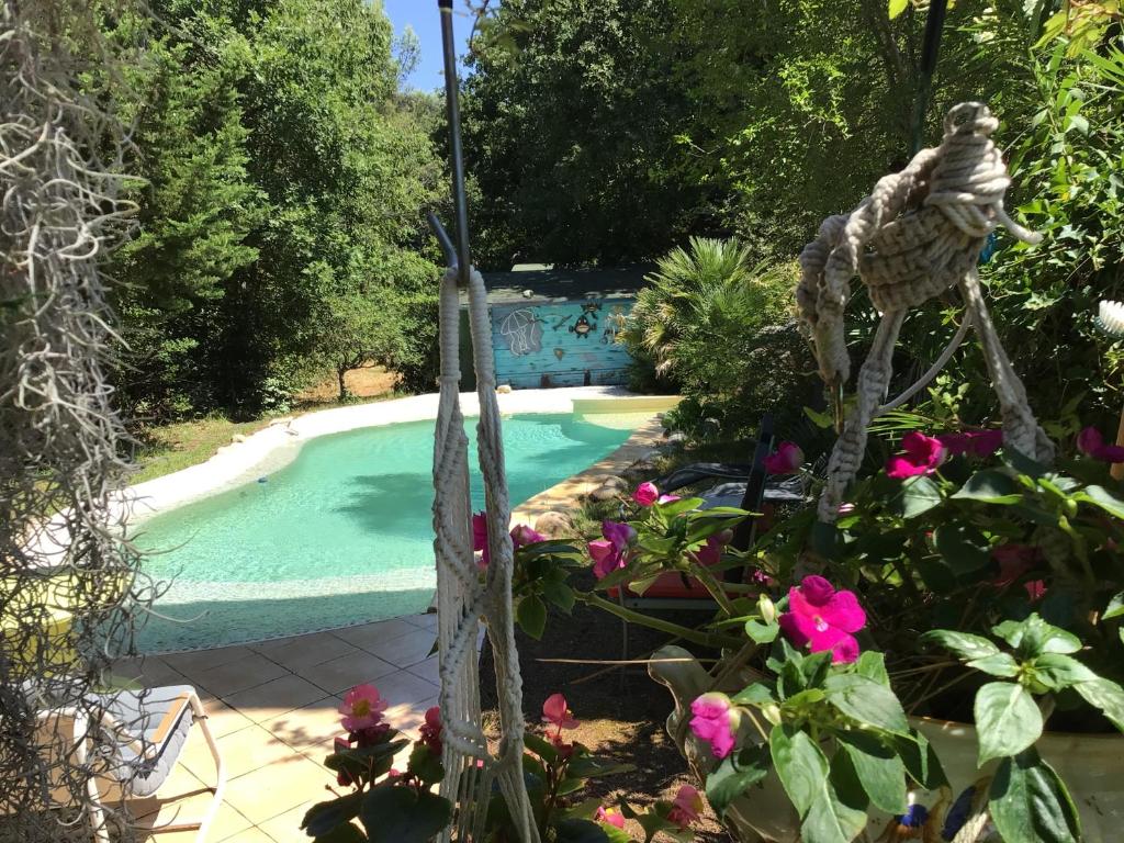a garden with a swimming pool and some flowers at Roulotte Fenouillet in Hyères