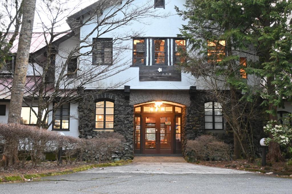 a stone house with a large door and windows at Village Kagetsuen in Yamanakako