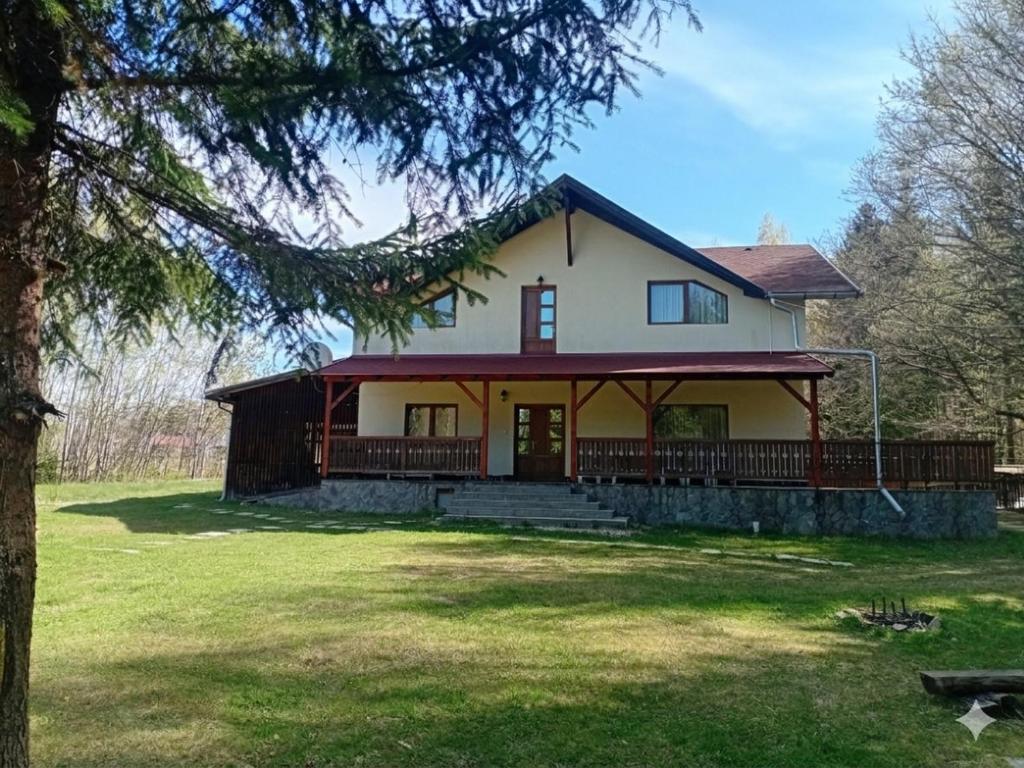 a large white house with a large porch at Fenyves Home in Izvoare