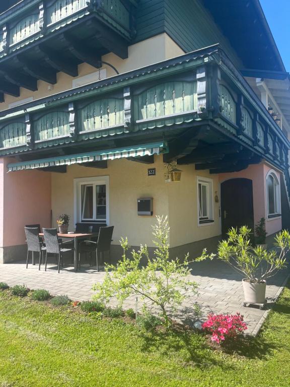 a house with a balcony with a table and chairs at Ferienwohnung Wasserfall in Golling an der Salzach